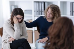 a person in a group therapy session is comforted during valium withdrawal