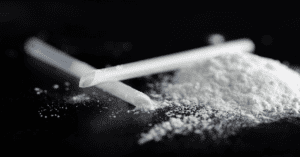 a pile of ketamine powder with two snorting straws next to it.