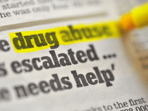 The words "drug abuse" are highlighted in yellow on a newspaper.