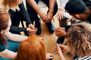 a group of people sits in a circle and participates in their ativan addiction treatment program