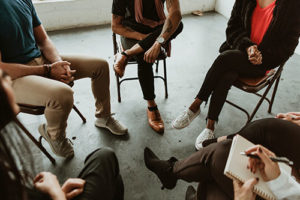 people sit in a circle talking and participating in a klonopin addiction treatment program