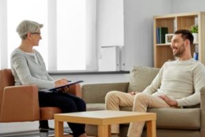 two people sit in charis and talk to each other in an individual therapy program