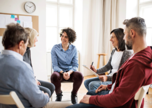People chat and laugh in group therapy activities