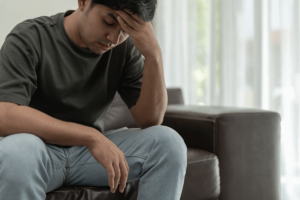 Man sits on couch in agony and ponders how addictive benzodiazepines are