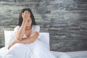Woman in bed struggles with both sleep and mental health