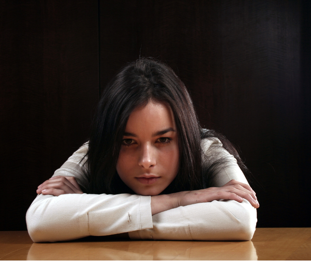 Woman rests head on hands feeling glumly